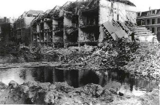 Omvangrijke krater in de Riouwstraat na het neerstorten van een V2, die neerkwam achter de huizen op 25 januari 1945. Verzameling HGA nr. 060458