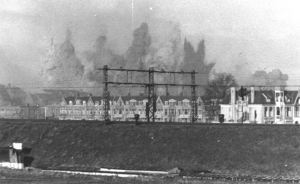 Bezuidenhout in brand gezien vanuit Voorburg over de spoorlijn Den Haag - Leiden en de Schenkkade. Foto door D. Dijkstra. Verzameling HGA, fotonr. 1945 III 74. Postbus 12600, 2500 DJ  Den Haag.